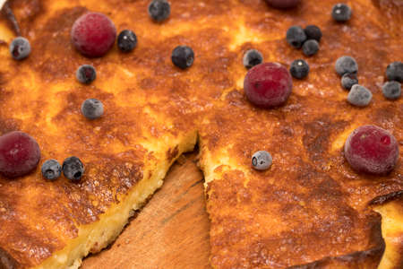 Cottage cheese casserole, cherries and blueberries in a rustic style