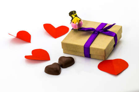 Gift with purple ribbon and candies in shape of heart on white background Valentine's Dayの写真素材