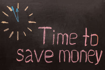 Time to save money - clock with text on black backgroundの写真素材
