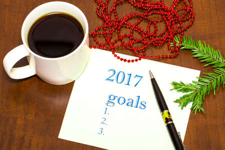 2017 list of goals on a sheet of paper, a wooden table with a Cup of coffeeの写真素材