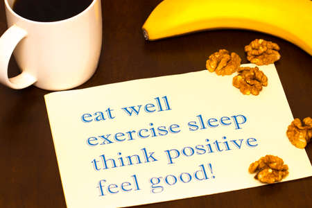think positively , exercise, eat well, sleep - concept feel good - handwriting on a sheet of paperの写真素材