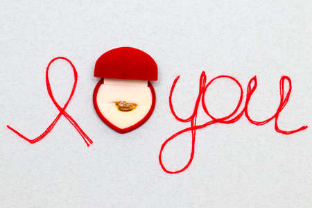 Love you words and heart symbol made of red thread on a white background for your Valentine's dayの写真素材