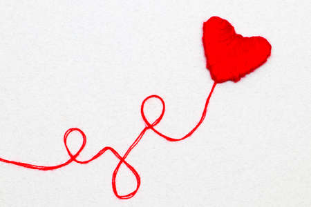 Red heart shape symbol made from wool isolated on white backgroundの写真素材