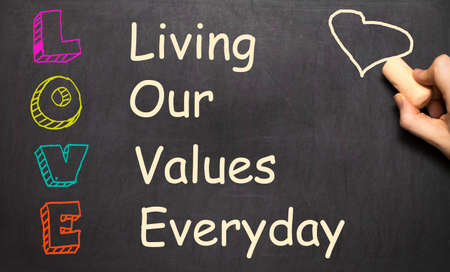 Conceptual LOVE acronym written on black chalkboard blackboard. Living our values everyday templateの写真素材