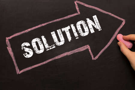 Solution - female hand with chalk and arrow with textの写真素材
