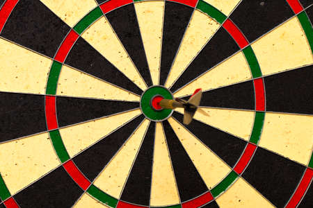 Dart arrow hitting in the target center of dartboardの写真素材