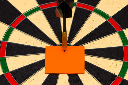 Darts with dart arrow which was pinned a sheet of paper for labelsの写真素材