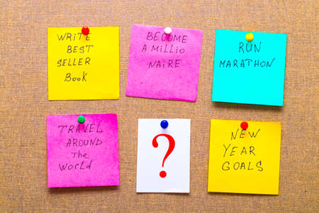 become a millionaire and other unrealistic new year goals or resolutions - colorful sticky notes on canvasの写真素材