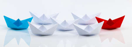 Leadership concept with red paper ship leading among white.の写真素材