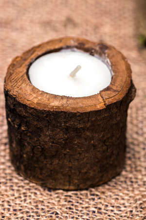 Candle in a wooden candlestick on a romantic background.の写真素材