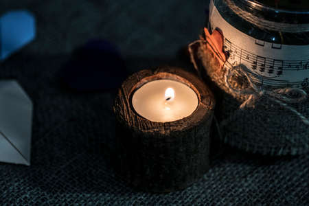 A white candle in a wooden candlestick.の写真素材