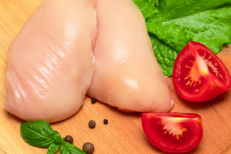 The Raw chicken breasts on cutting boardの写真素材