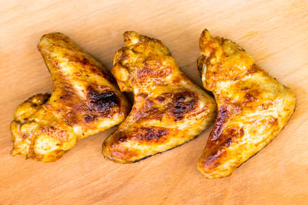 barbecue chicken wings close up on wooden tray shot with selective focus.の写真素材