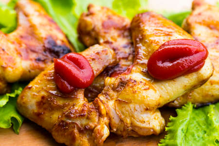 barbecue chicken wings close up on wooden tray shot with selective focus.の写真素材