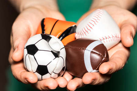 female hands holding Collection of sport ball with soccer, rugby, baseball and basket ball.