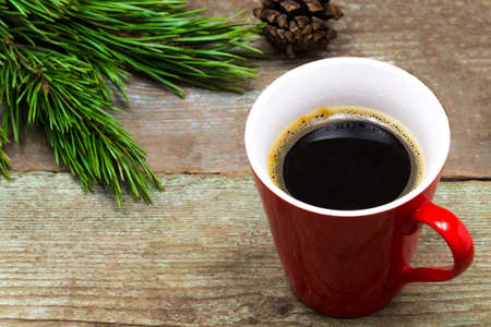 Christmas background with fir tree, cup of coffee on a wooden table.の写真素材
