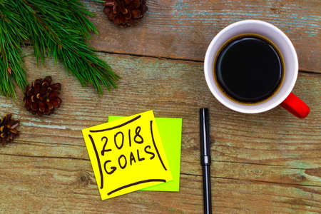 2018 goals - handwriting in black ink on a sticky note with a cup of coffee, New Year resolutions...