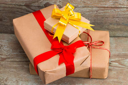 Gift boxes wrapped with kraft paper on wooden background, top view.
