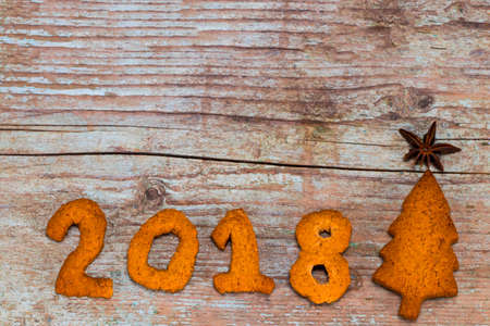 Gingerbread cookies on wooden table. Merry Christmas and Happy New Year 2018! Close up, top view....