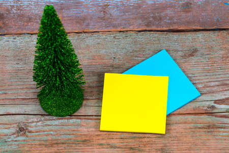 sticky note with empty space for a text and Christmas tree on wooden background.の写真素材