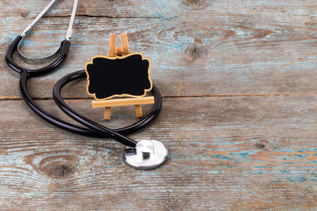 Stethoscope with blackboard with empty space for a text on wooden background.の写真素材