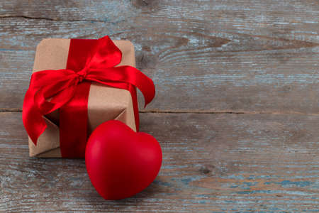 Gift box and red heart on the wooden background. Red ribbon. Valentine's Day gift.の写真素材