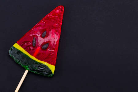 Sweet candy lollipop watermelon on a black background. Top view with copy space.の写真素材
