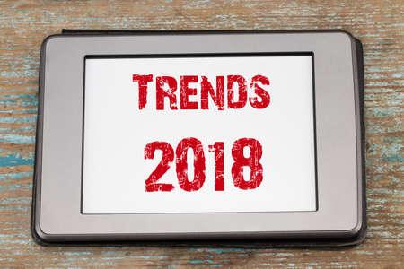 Trends 2018 inscription on  e-book screen on wooden table.の写真素材