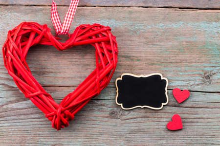 Valentine's day background with red hearts  and a blackboard on wooden planks. Space for text. Valentine's day concept.Top view.の写真素材