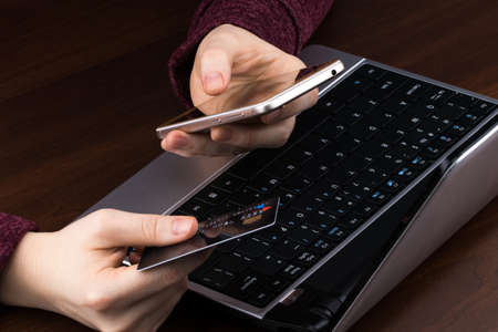 Hands holding credit card and using laptop. Online shopping.