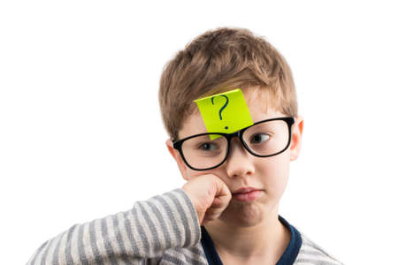 Confused boy thinking with question mark on sticky note on forehead.の写真素材