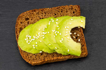 Avocado sandwich on dark rye bread made with fresh sliced avocados from above.の写真素材