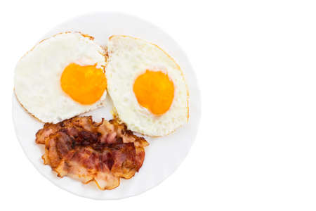 Plate with fried eggs and bacon on white background.の写真素材