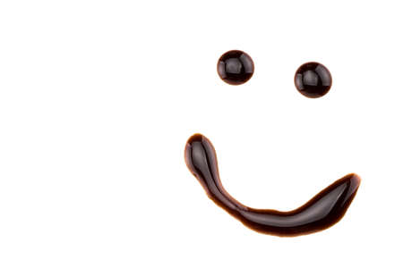 smile made from chocolate syrup, isolated on white.の写真素材
