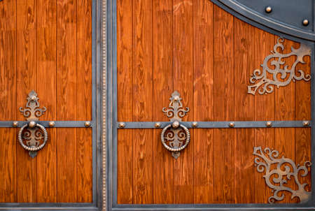 wooden gate with wrought iron elements close up.