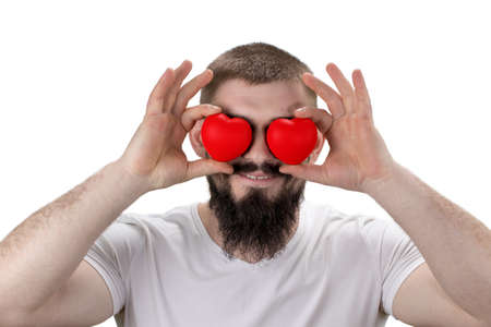 Close-up portrait of handsome bearded man closing eyes by red  hearts, isolated on white.の写真素材