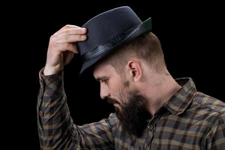 Side view of sad bearded man with hat looking down.の写真素材