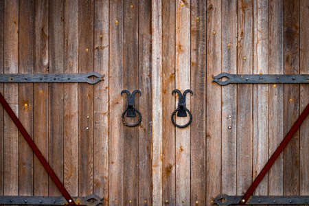 wooden gate with wrought iron elements close up.の写真素材
