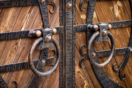 wooden gate with wrought iron elements close up.の写真素材