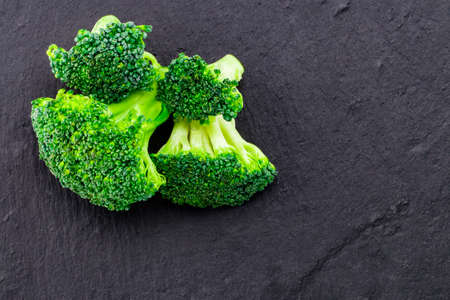 Fresh broccoli on a black slate, top view with space for text.の写真素材