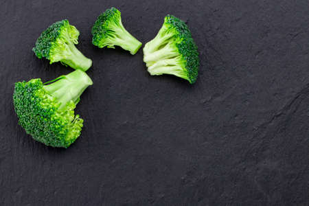 Fresh broccoli on a black slate, top view with space for text.の写真素材