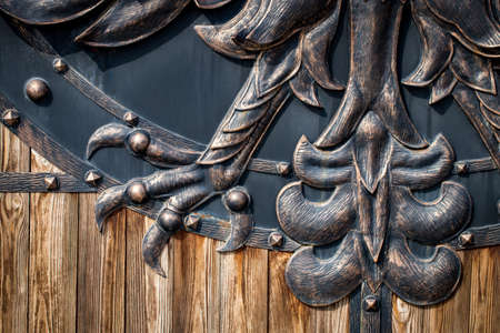 wooden gate with wrought iron elements close up.