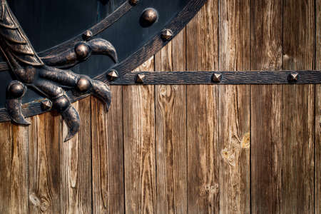 wooden gate with wrought iron elements close up.の写真素材