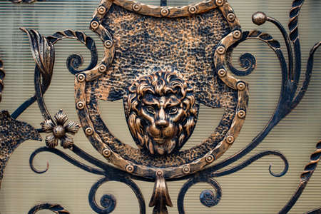 Details, structure and ornaments of forged iron gate. Decorative ornamen with lions , made from metal.の写真素材