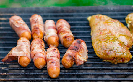 Assorted mixed grill from chicken meat, and pork, sausages  roasting on barbecue grid cooked for summer family dinner.の写真素材