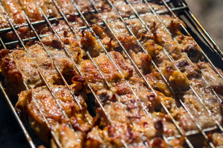 Grilled chicken thigh on the flaming grill.
