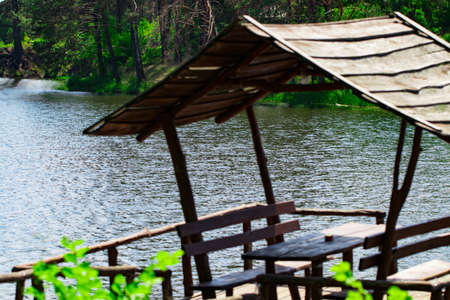 Relaxing gazebo built on the river against the forest.の写真素材