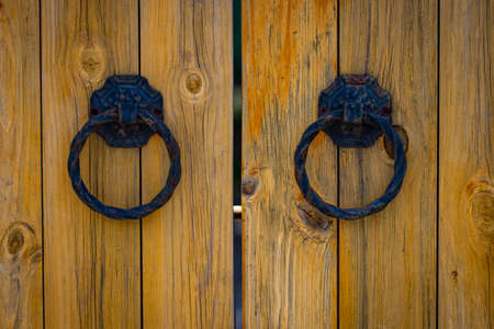 wooden gate with wrought iron elements close up.の写真素材