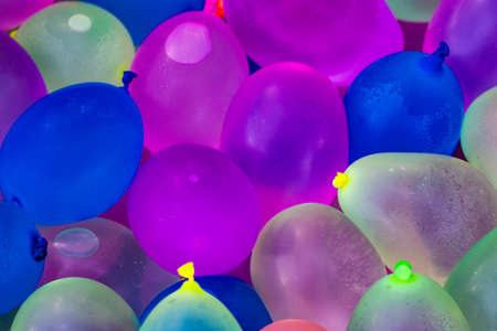 Many bright and colorful water balloons close up.の写真素材