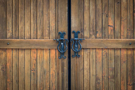 wooden gate with wrought iron elements close up.の写真素材